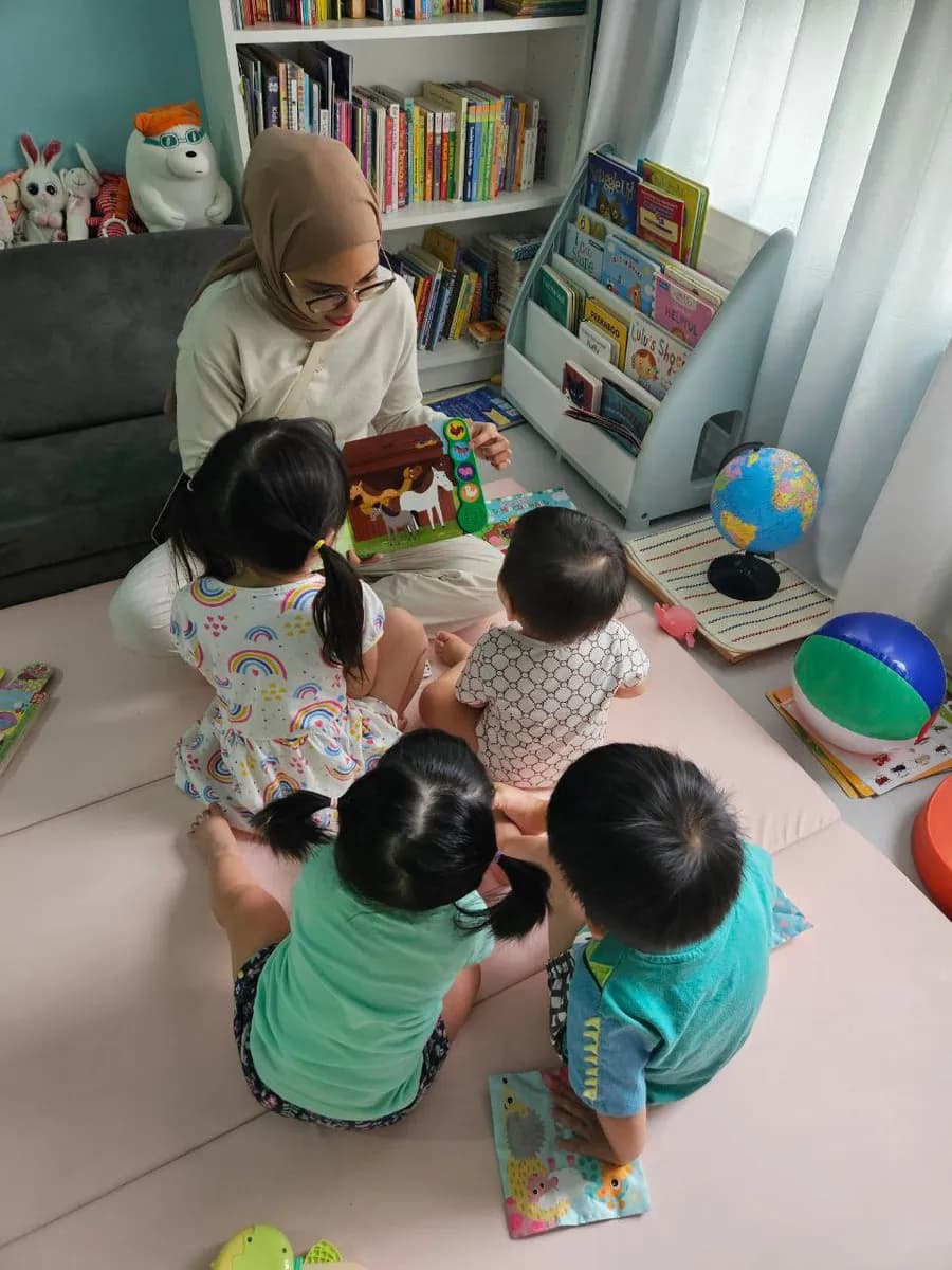 Caregiver reading with children at The Fun Cove
